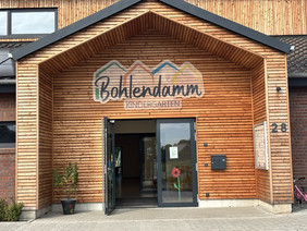 Eingangstür des Kindergarten, das Logo hängt groß vor dem Eingang