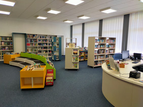 Offener Raum mit bunten Bücherregalen